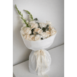 Cream and blush bouquet wrapped in white paper with a lace ribbon