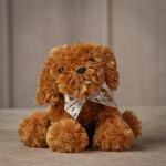 Brown plush dog with a patterned ribbon bow
