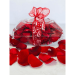 Clear gift box filled with red rose petals and tied with a red ribbon