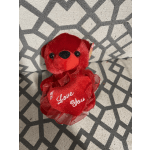 Red plush teddy bear holding a heart that says I Love You