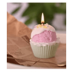 Pink and white cupcake with a lit candle in a paper wrapper