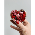 Heart-shaped clear box filled with red and pink candies