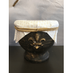 Decorative dark pedestal bowl with a white patterned cover and tied ribbon