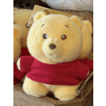Yellow teddy bear plush wearing a red shirt