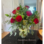 Red rose bouquet in a clear glass vase with a yellow ribbon