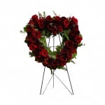 Heart-shaped wreath of red roses on a black stand