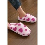 Pink heart-patterned slippers on a wooden floor