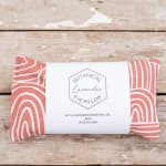 Lavender eye pillow in coral patterned fabric with a label