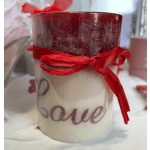 White candle in a glass jar tied with a red ribbon
