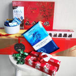 Assorted chocolate gift boxes and wrapped candy on a stool