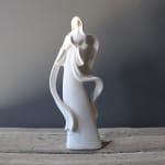 White ceramic angel figurine on a wooden surface