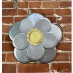Metal flower wall decor with silver petals and a yellow center