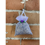 Small lavender mesh sachet bag hanging on a brick wall
