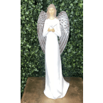 White angel statue with silver wings against a green foliage wall