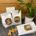 Dog treat bags beside a small potted plant