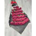 Large bouquet of red roses wrapped in black paper with a red bow