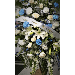 Standing sympathy spray with white lilies, roses, and blue carnations