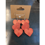 Pair of red heart-shaped dangle earrings on a cardboard card