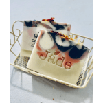 Two decorative soap bars with pink and black swirls in a small cream metal basket
