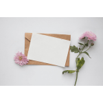 Pink flowers beside a blank card on a kraft envelope