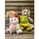 Four plush stuffed animals with colorful accessories on a wooden backdrop
