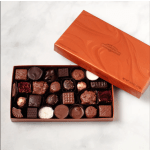 Open box of assorted chocolates with orange lid