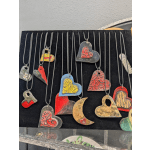 Heart-shaped metal pendants in assorted colors hanging on cords