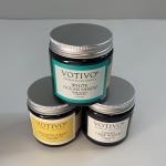 Three scented candles in dark glass jars with silver lids