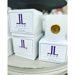 White LUSH Carnival boxes and a white candle jar with a gold emblem
