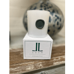 White candle in a box with a dark green logo