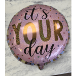 Pink foil balloon reading "it's YOUR day" with confetti dots
