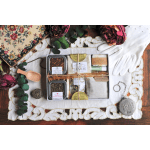 Gift box with tea tins, soap, and a linen pouch on a decorative cloth