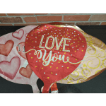Three heart-shaped foil balloons, including one that says "LOVE You"