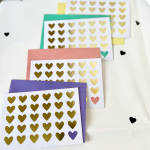 Stacked heart-pattern greeting cards with colorful envelopes
