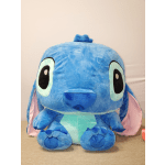 Large blue Stitch plush toy with pink ears sitting on a table