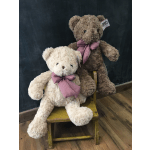 Two plush teddy bears with gingham bows sit on a small wooden bench.
