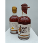 Two maple syrup bottles with white labels on a white surface