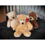Three plush teddy bears in cream, tan, and brown with ribbon bows