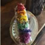 Rainbow-colored floral garland draped over a round mirror