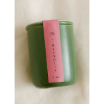 Green candle tin with a pink label reading fig + magnolia