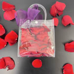 Clear pouch filled with red rose petals and tied with a purple ribbon