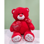 Red teddy bear holding a heart with a ribbon