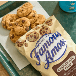 Chocolate chip cookies on a tray beside a Famous Amos cookie bag