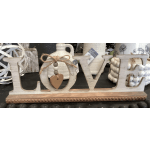 Wooden tabletop sign spelling LOVE with a hanging heart charm