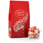 Red bag of Lindor milk chocolate truffles beside a small glass bowl filled with wrapped chocolates
