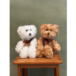 Two plush teddy bears sitting on a wooden table