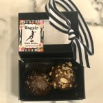 Box of two chocolate truffles with a striped ribbon and floral label