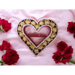 Heart-shaped box of chocolates surrounded by red roses on pink fabric
