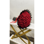 Large bouquet of red roses wrapped in black paper with a red ribbon