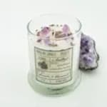 Glass candle jar with lavender flower petals and a purple decorative cluster